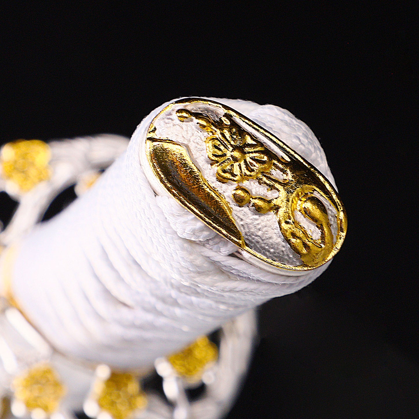 White handle tanto handle close-up - white tsuka wrap with floral fuchi detail